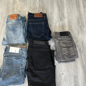 5x Jeans i olika färger från T/J - Säljer flera par jeans från T/J i olika färger: ljusblå, mörkblå, svart och grå. Klassisk femficksmodell med raka ben och snygga detaljer på bakfickorna. Perfekt för dig som gillar stilrena och tidlösa jeans med modern passform. Skriv för storlekar och priset går att diskutera 