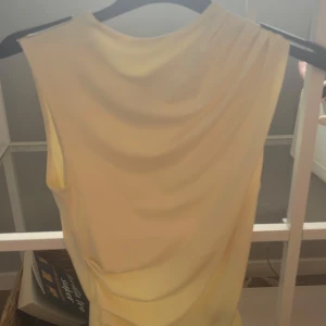 Ljusgul tröja med veckning från hm - Supersöt ljusgul ärmlös tröja från H&M Divided i storlek XS. Tröjan är aldrig använd utan bara testad,har dock ingen lapp då jag tänkte använda den men blev inte av därav ny pris💕