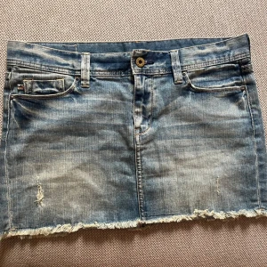 Jeans kjol från Ralph lauren - Snygg blå jeanskjol med slitna detaljer och fransig nederkant från Ralph Lauren. 44 cm midja. 