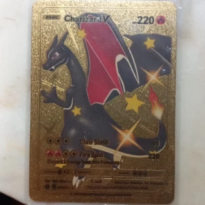 Charizard V - Exklusivt Charizard V-kort med glittrande gulddesign! Perfekt för dig som älskar Pokémon och vill ha något unikt i din samling. Kortet har coola attacker som Claw Slash och Fire Spin. Ett måste för både samlare och spelare som vill sticka ut.