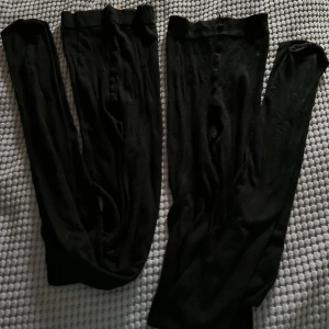 Svarta tunna strumpbyxor med fot - Två par svarta, tunna strumpbyxor med fot. Perfekta att bära under kjol eller klänning för en stilren look. Mjukt och stretchigt material som sitter bekvämt hela dagen. Ny utan prislapp/Aldrig använda 