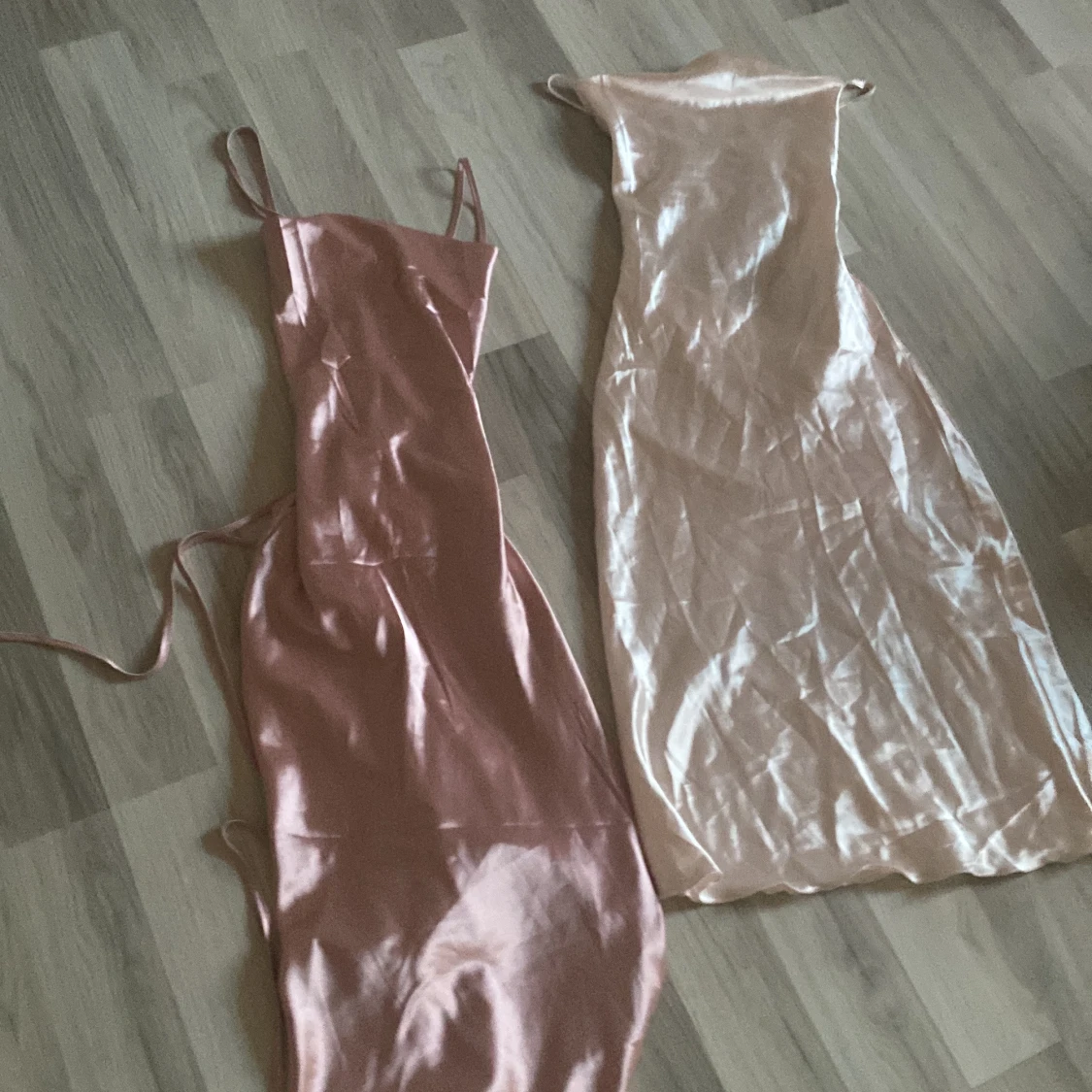 Två sidenklänningar i rosa och champagne