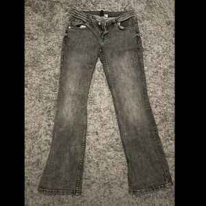 Grå bootcut jeans från H&M, stl 40 - Säljer ett par gråa bootcut jeans från H&M i storlek 40. Jeansen har klassisk femficksdesign, snygg tvättad look och raka ben som går ut lite nertill med en lågmidja. Perfekta till sneakers eller boots. Materialet är mjukt och bekvämt bomullsjeans.