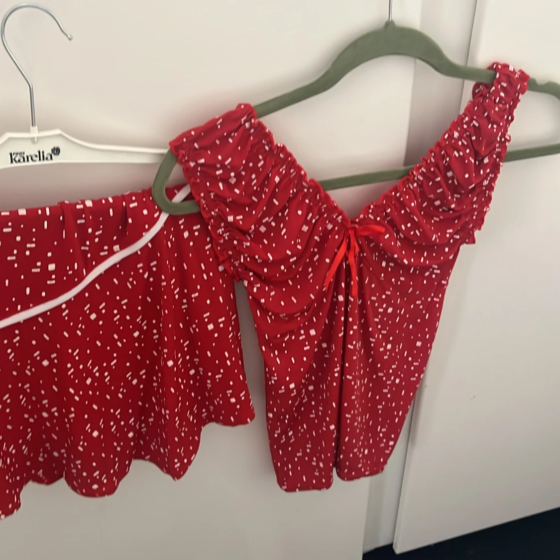 Röd kortklänning med vita mönster och rynkade axlar