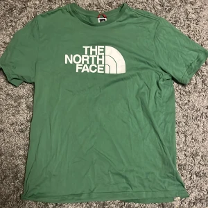 Grön t-shirt från The North Face - Snygg grön t-shirt från The North Face med stort vitt logotryck på bröstet och mindre logga på ryggen. 