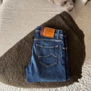 Jacob Cohën NICK Jeans - Nästintill oanvända JC-jeans i modellen ’Nick’. En exklusivare modell med badge i koskinn med stygn som detalj, samt knappar i brons-finish.   Kondition: 10/10  Nypris: 5199 SEK.