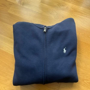 Mörkblå hoodie med dragkedja från Polo Ralph Lauren - Säljer en mörkblå Ralph Lauren hoodie med dragkedja. På bröstet är det en vit snygg Raffe logga. Tröjan är i mycket bra skick då den knappt är använd. Pris kan diskuteras👌🙌