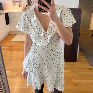 Missguided petite klänning - Supersöt vit klänning med svarta prickar, även små ”rosa” prickar som knappt är synliga. Den har snörning i midjan och volanger upptill och nertill. Väldigt fint skick och är väldigt söt och somrig