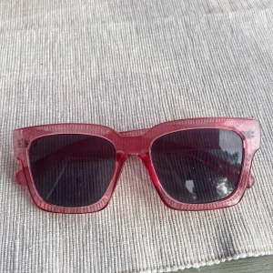 Rosa fyrkantiga solglasögon - Snygga solglasögon med transparent rosa båge och mörka glas. Modellen har en trendig, fyrkantig form! Från Ur&penn säljer för 40kr