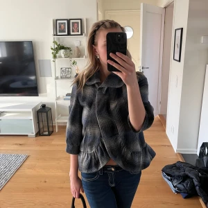 Grå och svart rutig jacka med krage - Säljer en grå och svart rutig jacka med krage och knappar framtill. Jackan har en superfin passform med trekvartsärmade ärmar. Perfekt för dig som gillar en trendig stil.💕💕använd endast en gång så är därför i väldigt fint skick!
