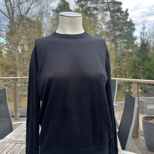 Svart tröja från Uniqlo - En enkel svart tröja från Uniqlo i storlek M. Tröjan har rund halsringning och långa ärmar, perfekt för lager-på-lager eller som basplagg. Mjuk och bekväm, passar till det mesta i garderoben.