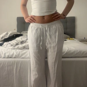 Vita linnebyxor med resårmidja - Säljer ett par luftiga vita linnebyxor med resår i midjan och raka ben. Byxorna har en bakficka och är perfekta för varma dagar. Sköna och stilrena, passar till många olika outfits. Har klippt bort lappen så ser inte vilken storlek men skulle säga S !! Aldrig använda 