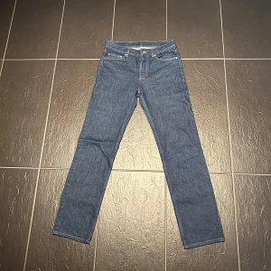 Blå raka jeans - Klassiska blå jeans med rak passform och fem fickor. Byxorna har normal midja och stängs med dragkedja och knapp. Perfekta för en enkel och stilren look.