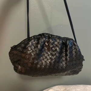 Jackie väska  - Jackie väska braided clutch i svart, går att ändra längd på bandet köpt för 2400kr jätte bra skick 