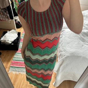 Färgglad långklänning med zigzag-mönster - Säljer en stickad långklänning i vackra mönster. Den är ribbad upptill och har korta ärmar. Perfekt till sommaren! 