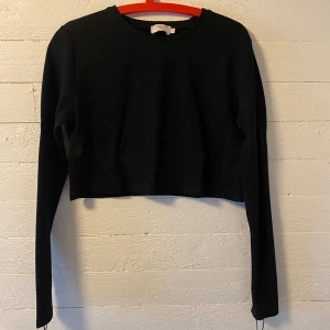 Svart croppad långärmad topp från NAKDxHanna Schönberg x NA-KD - Svart croppad långärmad topp från Hanna Schönberg x NA-KD. Använd 2 gånger, som ny 😇