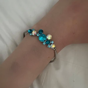 Armband med blå och skimrande stenar - Jätte vackert blått armband med blåa kristaller. Vet inte märke. Aldrig använd för den är tyvärr för stor för min hand! Be gärna om mått om ni vill! 🩵