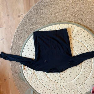 Mörkblå långärmad tröja från GANT - Säljer en klassisk mörkblå långärmad tröja från GANT med broderad logga på bröstet. Tröjan har rund halsringning och är tillverkad i bomull. Perfekt för en stilren och tidlös look. Storlek 176 cm (16 år) Väldigt bra skick