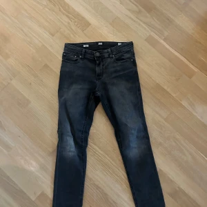 Svarta skinny jeans från Jack & Jones - Säljer ett par svarta skinny jeans från Jack & Jones. Jeansen har fem klassiska fickor, bälteshällor och dragkedja med knapp. Snygg tvättad look och smal passform som sitter tight hela vägen ner.