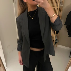 Grå kavaj i oversized modell - Snygg grå kavaj med klassisk krage och långa ärmar. Oversized passform som ger en trendig look. Perfekt att styla med svarta byxor och topp för en stilren outfit.☺️