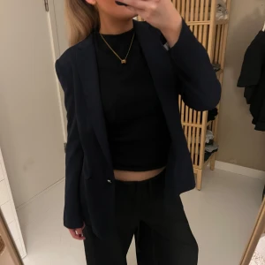 Mörkblå kavaj - Snygg mörkblå kavaj med klassisk passform och enkel knapp framtill. Perfekt att styla med både t-shirt och skjorta. Tidlös design med smala slag och diskreta fickor.☺️