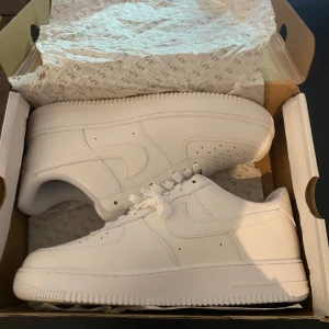 Nike Air Force 1 - Klassiska helvita Nike Air. Skorna är helt nya, endast testade. Perfekta för dig som gillar en clean och tidlös stil. Vid frågor eller fler bilder så finns jag i DM. Priset kan diskuteras vid snabbaffär!