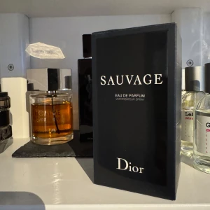 Sauvage Eau de Parfum från Dior - Sauvage Eau de Parfum från Dior är en herrparfym i en elegant, mörkblå glasflaska med silverdetaljer och tydlig Dior-logga på locket. Doften är intensiv och modern, perfekt för dig som gillar exklusiva och fräscha parfymer.