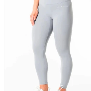 Grå träningskläder  - Snygga gråa tights med hög midja och tight passform. Perfekta för träning och har en stilren design utan synliga detaljer. Materialet är stretchigt och känns mjukt mot huden. Även en grå sporttopp. Använda fåtal gånger. Priset gäller för båda tillsammans 