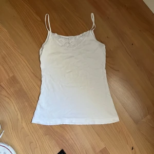 vitt linne med spets - vitt linne med spets vid urringningen.