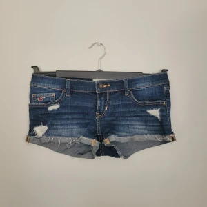 Mörkblå jeansshorts från Hollister - Säljer mina jätte snygga jeansshorts från hollister då de tyvärr var lite små. Väldigt lågmidjade, mycket fina detaljer och passar perfekt till sommaren. Aldrig använt de så väldigt bra skick💕