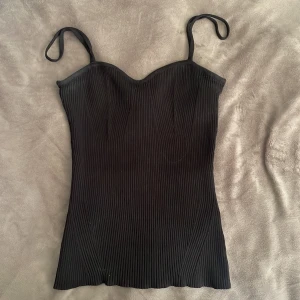 Svart ribbad linnetopp Gina Tricot - Svart ribbad linnetopp från Gina Tricot som har varit använd ett fåtal gånger🙃 pris kan diskuteras!🤗🌸