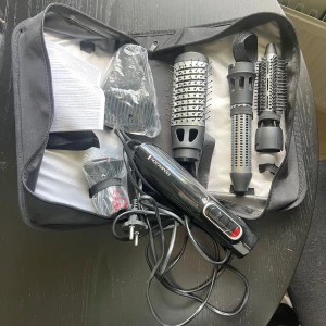 Remington stylingverktyg med borstar - Säljer ett Remington stylingverktyg med flera utbytbara borstar och munstycken, perfekt för att skapa olika frisyrer. Allt kommer i en smidig svart förvaringsväska. Verktyget är svart med röda detaljer och har sladd med EU-kontakt.