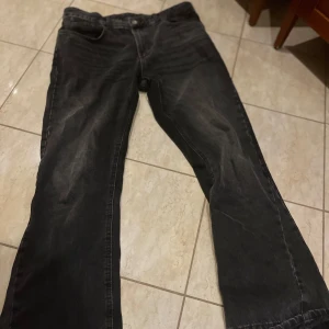 Svarta bootcut jeans från Zara - Svarta jeans från Zara med bootcut passform och råa, fransiga benslut för en avslappnad vibe. Jeansen har klassisk femficksdesign och är tillverkade i denim. Perfekta för dig som gillar en lite bredare siluett nertill.