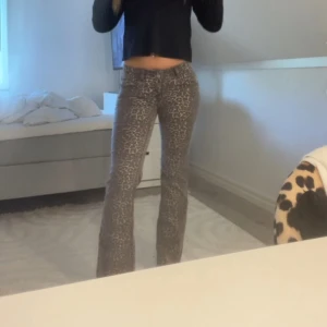 Leopardmönstrade bootcut byxor - Snygga byxor med leopardmönster i grå och beige toner. Modellen har bootcut-ben och sitter tajt upptill med en något utsvängd passform nertill. Perfekta för dig som vill sticka ut lite extra. Materialet känns mjukt och stretchigt.