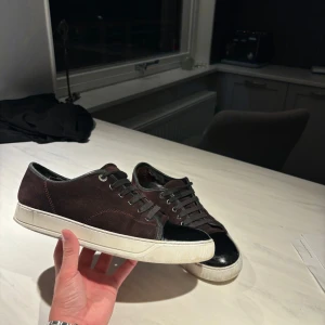 Lanvins - Snygga vin röda Lanvins med svart lackad tå. Storleken är i UK7/strl 41, passar även 42. |INGET OG| det ända som är lite negativt är att dom är lite trasiga i hälarna som på det flesta skor. Priset går att diskutera vid snabb och smidig affär:)