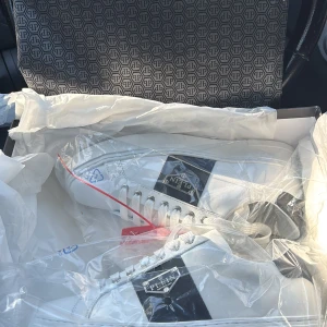 Vita sneakers från Philipp Plein - Snygga vita sneakers från Philipp Plein med svarta detaljer och metallogo på sidan. Skorna är helt nya inte använda fick fel storlek så tänkte testa sälja dem här dem kostar 6000kr men säljer dem endast för 3000kr, Skorna har klassisk rund tå, platt sula och breda vita snören. Tillverkade i skinn för en lyxig känsla och stilren look. Perfekta för dig som vill sticka ut med exklusiva detaljer.