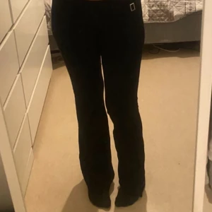 Svarta stickade yoga pants med spänne - Säljer ett par svarta stickade yoga pants med snyggt silverfärgat spänne i midjan. Byxorna har låg midja och är i ett stretchigt material som sitter skönt. Perfekta om du vill ha en stilren och trendig look.