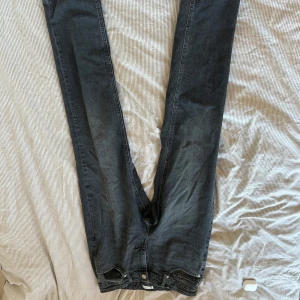 Mörkgrå jeans från C, 32/32 - Snygga mörkgrå jeans från C i klassisk rak modell. Jeansen har fem fickor, knappgylf och diskret tvättad look. Perfekta för dig som gillar en stilren och enkel vibe. Materialet är slitstarkt denim i bomull.