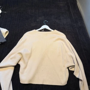 Beige stickad tröja - Enkel och stilren beige stickad tröja med avslappnad passform och långa ärmar. Den är lite tajtare till midjan. Är i storlek xxs men passar om man normalt har storlek S Skriv för fler bilder💕