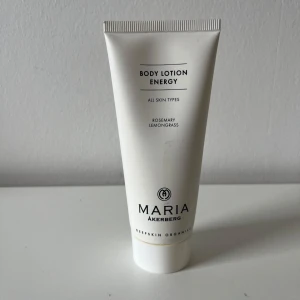 Body Lotion Energy från Maria Åkerberg - Body Lotion Energy från Maria Åkerberg med eteriska oljor av rosmarin och citrongräs. Vit tub på 100 ml, vegansk och ekologisk formula som återfuktar huden och ger en fräsch doft. Perfekt för dig som gillar naturliga ingredienser och vill boosta huden med vitaminer.