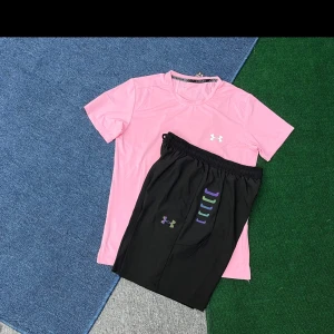 Rosa Under Armour t-shirt - Fräsch rosa t-shirt från Under Armour med klassisk logga på bröstet. T-shirten har rund hals och korta ärmar, perfekt för träning eller chill. Materialet är lätt och andas, vilket gör den skön att ha på sig när du är aktiv.