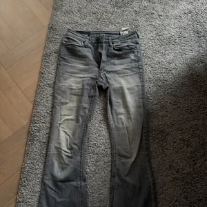 Grå bootcut jeans från Dondup - Snygga grå jeans från Dondup med bootcut passform och klassisk femficksdesign. Jeansen har slitningar och en tvättad look. Tillverkade i mjukt bomullsmaterial och har normal midja. Perfekta för dig som gillar en avslappnad men trendig stil.