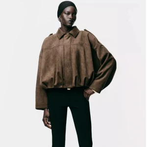 Oversized brun mockajacka - Säljer en oversized brun jacka i mocka-look med bred krage och dolda knappar framtill. Jackan har långa ärmar, markerade axlar och en cool, loose passform som ger en modern siluett. Perfekt för dig som gillar statement-plagg och vill sticka ut. Storlek S från Zara.