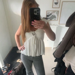 Grå bootcut byxor med sömdetaljer - Snygga grå byxor med bootcut och markerade sömmar längs benen. De har en klassisk dragkedja framtill och sitter tajt upptill med utsvängda ben. Perfekta för dig som gillar en stilren look med lite edge.