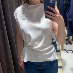 Vit Zara blus  - Säljer denna jätte snygga vita blusen från Zara då den inte kommit till användning. Blusenr perfekt att matcha med jeans eller kjol för en clean stil. Ny pris 399kr, pris kan diskuteras💗