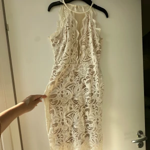 Klänning  - Letar du efter det ultimata statement-plagget för ditt nästa evenemang? Sök inte längre! Vår ärmlösa, rygglösa festklänning utstrålar elegans och sofistikering. Med sin eleganta design och smickrande silhuett är denna klänning perfekt för att göra en