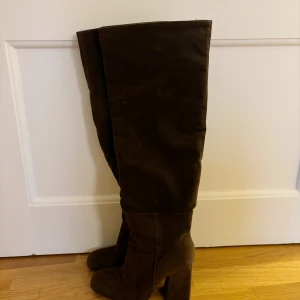 Bruna knähöga stövlar  - Bruna knähöga stövlar i suede. Endast använda ett fåtal  gånger då de tyvärr är förstora. Storlek 38. 