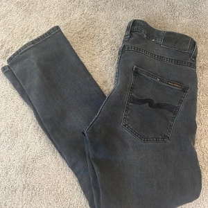 Nudie Jeans Grim Tim - Jag säljer ett par Nudie Jeans i modellen grim tim. Jeansen är i ett mycket bra skick. Nypris 1600 
