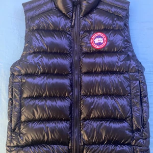 Canada Goose Väst - Svart Canada Goose väst. Storlek Medium Nyskick. Inga skador/smuts, Endast buren en vår. Köpt på NK !kvitto finns!
