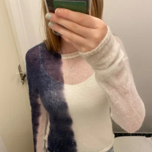 Vit och blå stickad tröja från Weekday - Säljer en supercool stickad tröja från Weekday. Den är vit med en blå färgblock på ena sidan och är långärmad. Perfekt för höst och vinter, och den är i nyskick. Tröjan är både stilren och unik, perfekt för att sticka ut i mängden!